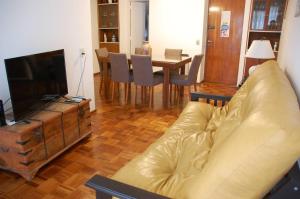 a living room with a couch and a television and a table at Bubuhouse estadía mínima dos noches in Rosario