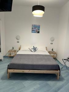 um quarto com uma cama grande e um piso azul em Blue sea b&b em Castellabate