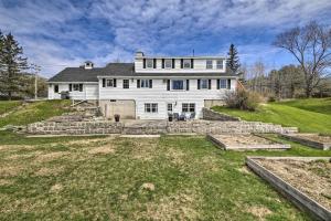 a large white house on top of a hill at Cozy Colonial Home with Bay Access and Water View in Bucksport