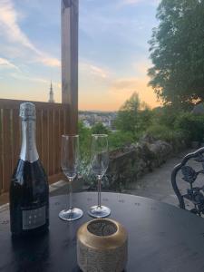 a bottle of wine and two glasses on a table at Suite Tino - Jacuzzi privé, cabine infrarouge & vue in Verviers