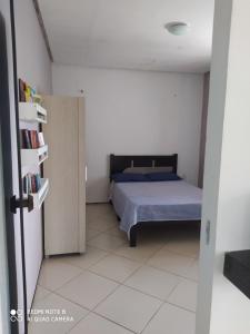 1 dormitorio con cama y estante para libros en Apartamento agradável de ótima localizacao en Viçosa do Ceará