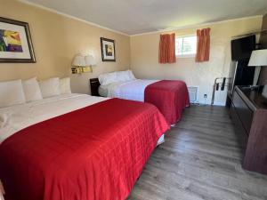 a hotel room with two beds and a flat screen tv at Beachway Motel in Salisbury