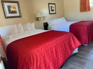 two beds in a hotel room with red and white blankets at Beachway Motel in Salisbury