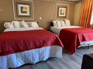 a hotel room with two beds with red and white sheets at Beachway Motel in Salisbury