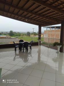 a patio with chairs and a table and a view of a field at Apartamento agradável de ótima localizacao in Viçosa do Ceará