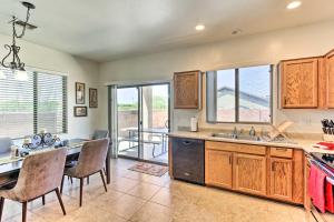 a kitchen with wooden cabinets and a table and chairs at Sahuarita Retreat with Grill about 24 Mi to Tucson! in Green Valley