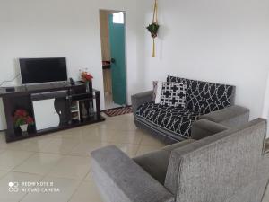 sala de estar con 2 sofás y TV de pantalla plana en Apartamento agradável de ótima localizacao en Viçosa do Ceará