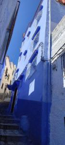 a blue building with stairs and windows on it at Casa Lotfi 1 in Chefchaouene