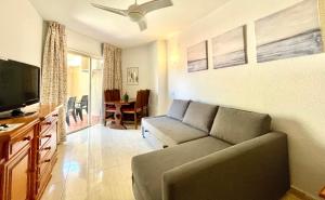 uma sala de estar com um sofá e uma televisão de ecrã plano em Chinasol Playa em Almuñécar