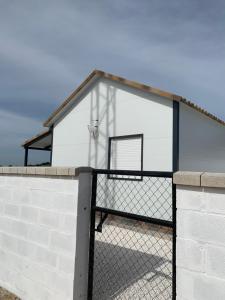 ein Gebäude mit einem Basketballkorb und einem Zaun in der Unterkunft El principito in Vejer de la Frontera
