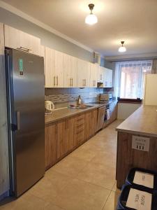 a kitchen with a stainless steel refrigerator and wooden cabinets at Spiska Sadyba in Łapsze Niżne