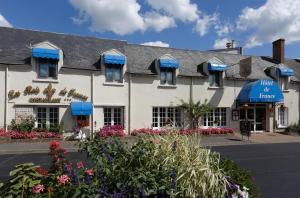 - un bâtiment blanc avec des parasols bleus dans l'établissement Contact Hôtel de France Contres-Beauval-Cheverny, à Contres
