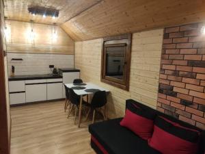 Habitación con cocina y mesa con sillas. en Domki letniskowe Kama 514-280-102, en Solina