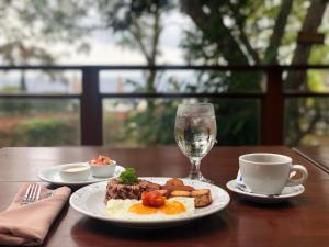 a plate of food and a glass of wine on a table at Pacaya Lodge and Spa in La Laguna