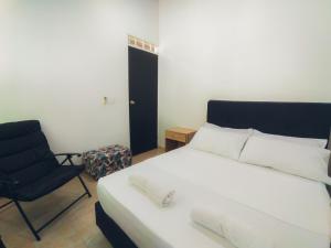 a bedroom with a large white bed and a chair at Casa de descanso con Jacuzzi privado - Girardot in Girardot