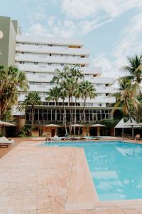 a swimming pool in front of a large building at Selina Foz in Foz do Iguaçu