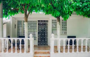 una valla blanca con árboles delante de una puerta en Casa de descanso con Jacuzzi privado - Girardot en Girardot
