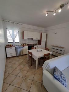 a kitchen and living room with a table and a couch at Bougainvillea in Marina di Modica +6 photos