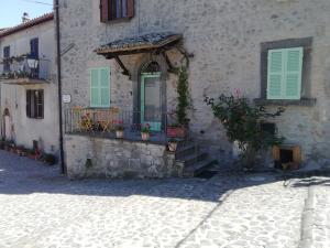 a stone building with a door and a balcony at LA CASITA in Orvieto