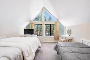 a bedroom with two beds and a large window at The Painted Bear in Woodlands
