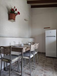 eine Küche mit einem Tisch und Stühlen sowie einem Kühlschrank in der Unterkunft House Theofilos in Paramonas