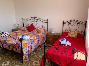 a bedroom with two twin beds with red sheets at Sunset in Trapani