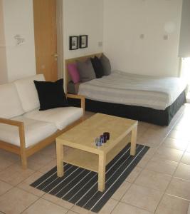 Sala de estar con 2 camas, sofá y mesa de centro en Lykavitos Apartments en Nicosia