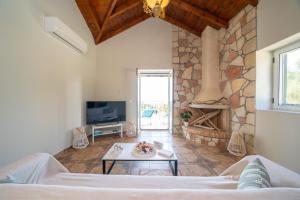 ein Wohnzimmer mit einem Sofa und einem Kamin in der Unterkunft Stone Villa Eriphyle ,private witn sunset view in Fiskardo