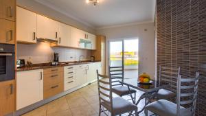 a kitchen with a table and chairs and a dining room at Quinta da Arbrotea in Lagos