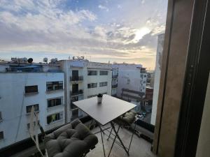 einen Tisch und Stühle auf dem Balkon eines Gebäudes in der Unterkunft Appartement Morillon 47 ou 39 au quartier Maarif in Casablanca