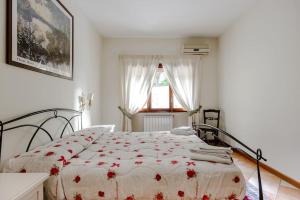 ナポリにあるNapoli Charming Apartments Salvator Rosa "Cool and Sweet" Parking Freeの白いベッドルーム(花柄のベッドカバー付)