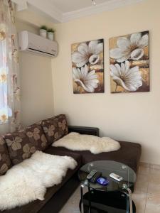 a living room with a couch and two pictures on the wall at MyParalia apartament ***** in Paralia Katerinis