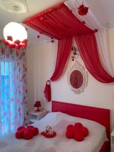 a bedroom with a red bed with red pillows on it at MyParalia apartament ***** in Paralia Katerinis