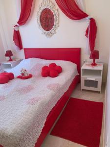 a bedroom with a red and white bed with red pillows at MyParalia apartament ***** in Paralia Katerinis