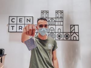 Un uomo con una maschera facciale con un cartellino di Centro Hostel Medellin a Medellín