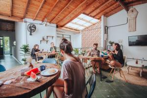un grupo de personas sentadas en mesas en un restaurante en Centro Hostel Medellin, en Medellín