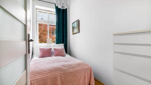 Habitación pequeña con cama y ventana en Comfy Apartments - Centrum Monte Cassino en Sopot