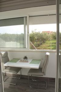 a table and chairs in front of a window at Mihaela studio apartmans 150m near the beach in Kaštela