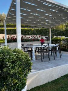 a patio with a table and chairs under a pavilion at La Dama in Poggio Murella