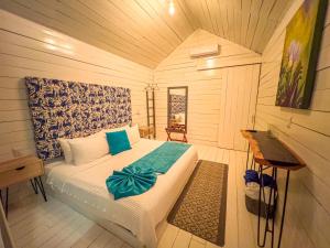a bedroom with a bed and a desk in it at Zensus Eco Boutique Hotel in Bacalar