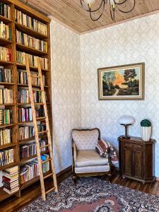 una habitación con una silla y estanterías con libros en Spacious 1-bedroom apartment with Sauna, en Rakvere