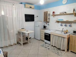 eine Küche mit einem Kühlschrank, einer Spüle und einem Tisch in der Unterkunft CASA NUNZIATINA in Neapel