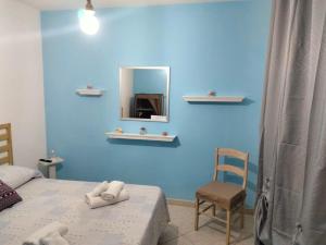 ein Schlafzimmer mit einer blauen Wand, einem Bett und einem Spiegel in der Unterkunft CASA NUNZIATINA in Neapel