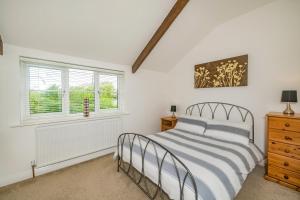 a bedroom with a bed and a window at Penbarden Barn in Bude
