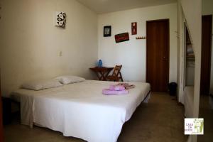 Un dormitorio con una cama con una toalla morada. en Casa da Gente, en Río de Janeiro