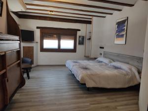 a large bedroom with two beds and a television at Hostal Suetxe in Los Arcos