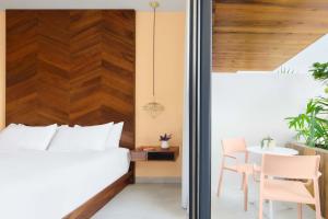 a bedroom with a bed and a table at CALIXTA Hotel in Playa del Carmen +96 photos