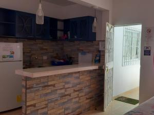 a kitchen with blue cabinets and a brick wall at Preciosa Suite Familiar Dep-31 in Playas +8 photos