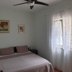 um quarto com uma cama e uma ventoinha de tecto em Sophos em Supetar
