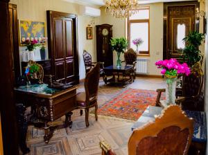 Royal Antique Boutique Hotel في باكو: غرفة معيشة فيها بيانو وطاولة وكراسي